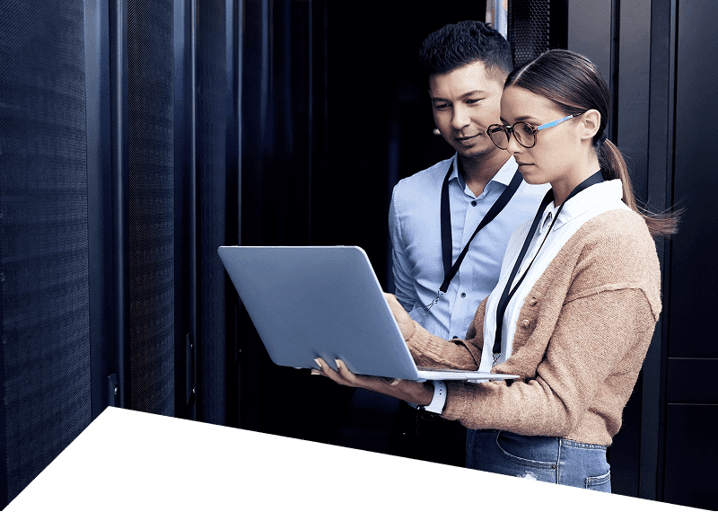 Two people working on a laptop server.
